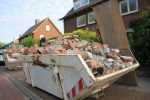 White roll-off skip bin overflowing with red brick and concrete demolition debris on a residential street corner.